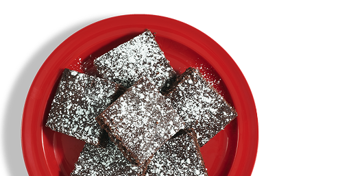 A red plate stacked with chocolate brownies.