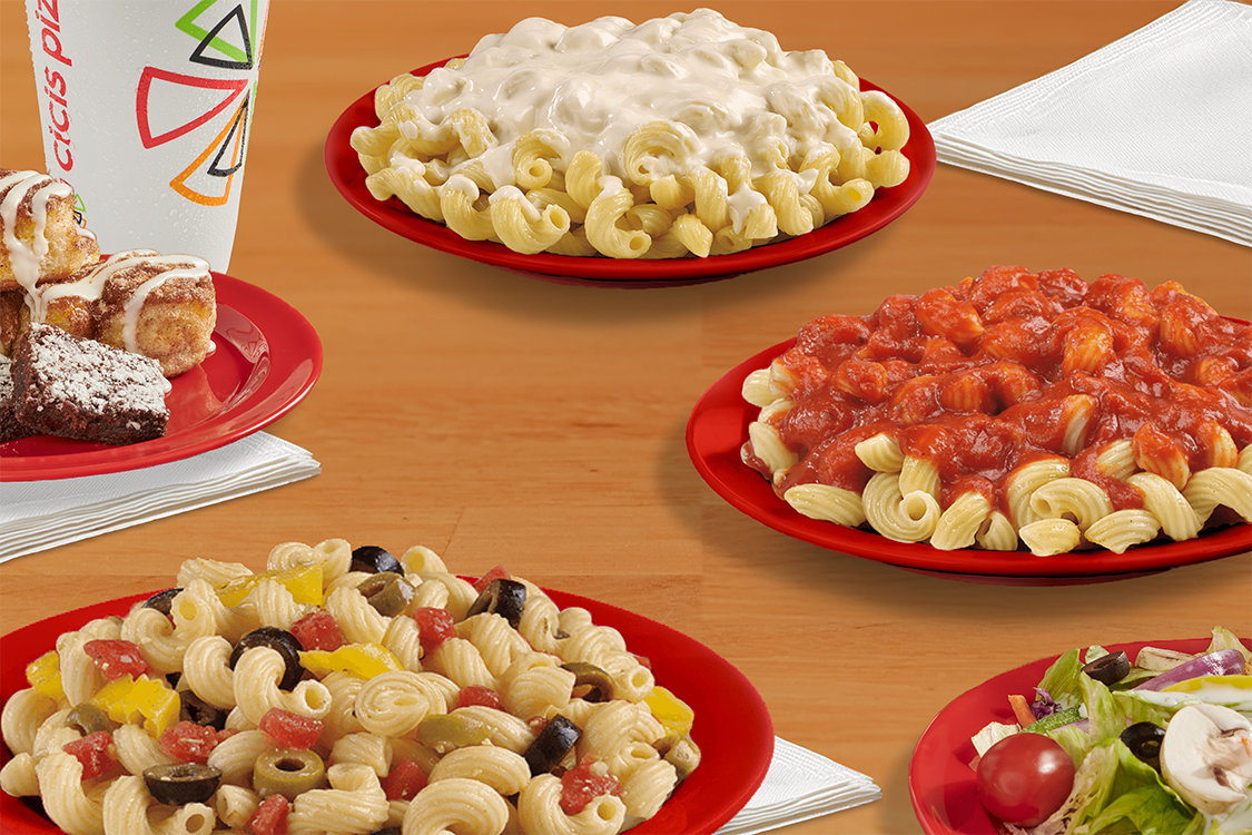 Three pasta dishes on a wood table