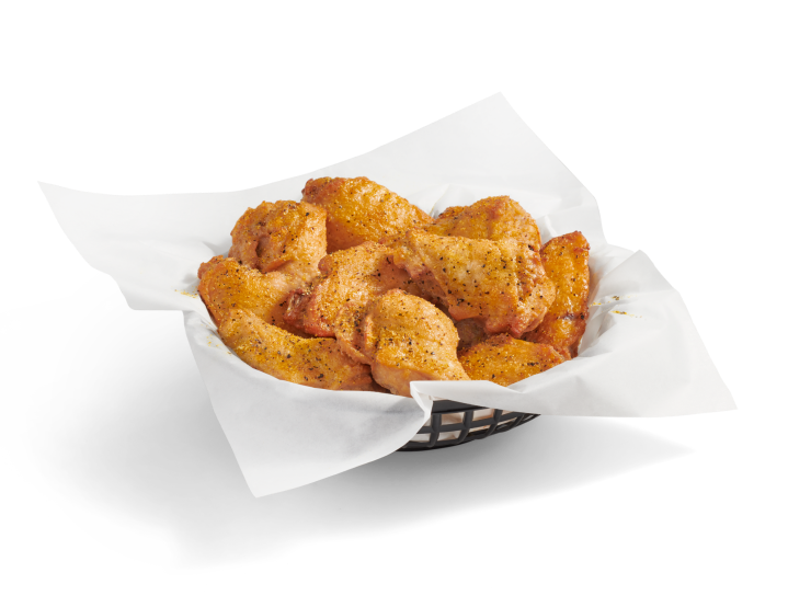 A full basket of crispy, bone-in chicken wings coated in lemon pepper sauce.