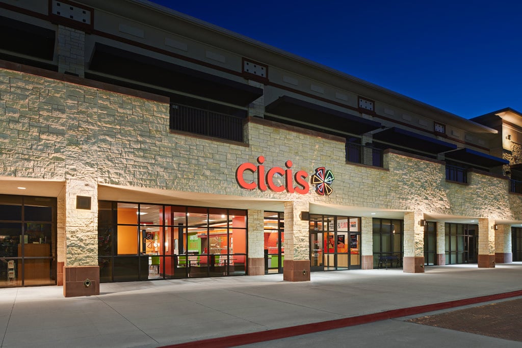 Brick exterior of Cicis Pizza restaurant at night. There is a lit up "Cicis Beyond Pizza" sign above the entrance.
